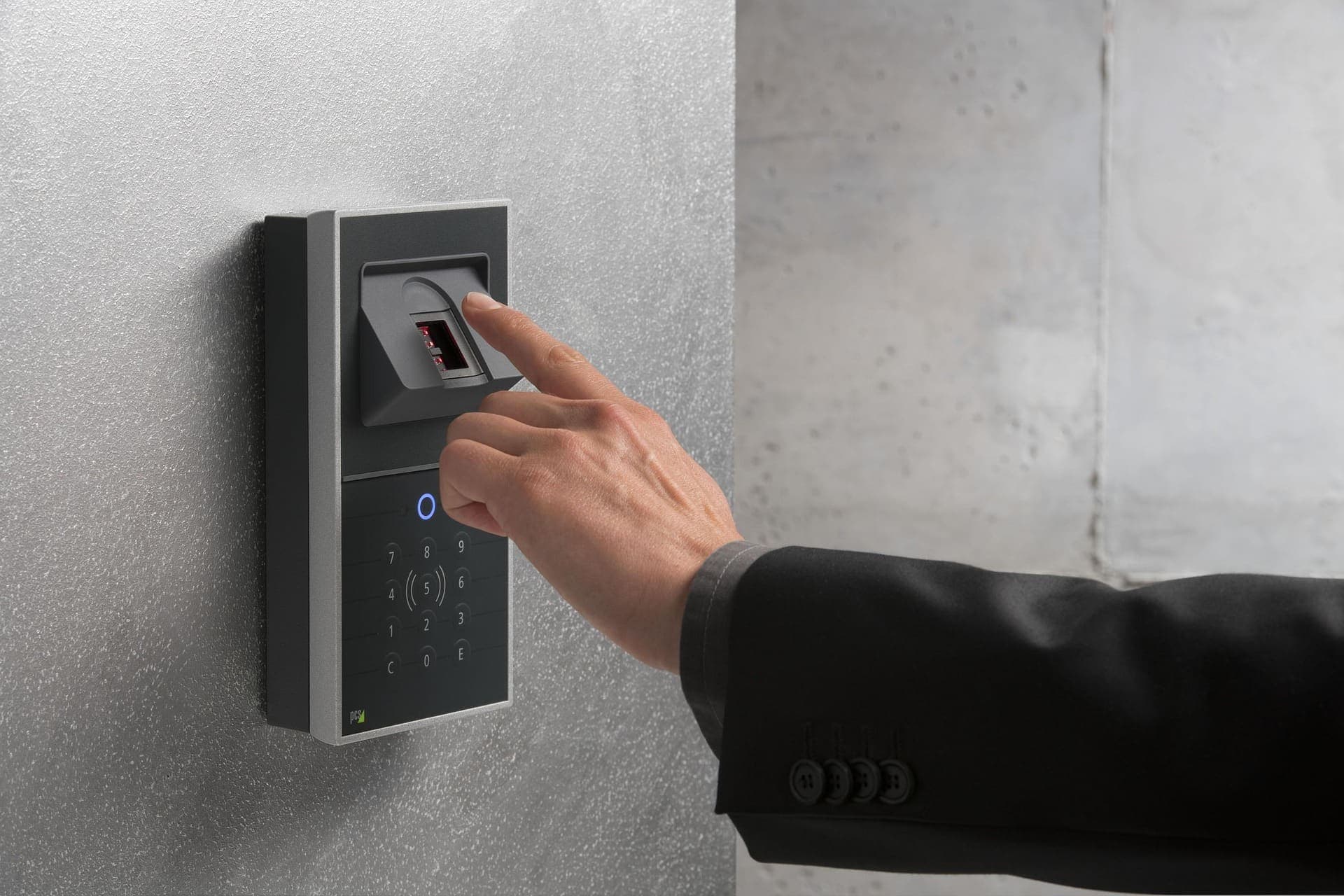 Person using a wall-mounted access terminal at a building entrance